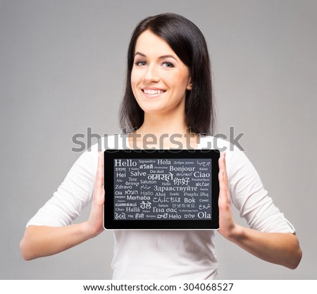 Teenager girl with a tablet computer. Different world languages concept.