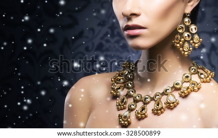 Young, beautiful and rich woman in jewels of platinum and stones over winter Christmas background
