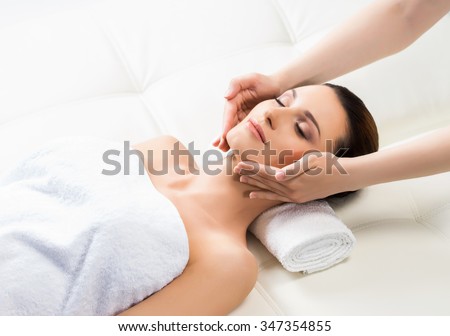 Beautiful woman laying on a mat in massage salon.