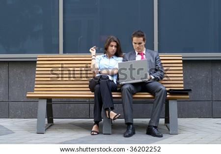 Business couple sitting on the bench