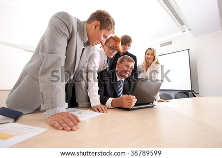 Wide angle shoot of business group of two young ladies, two young men and a mature boss at work isolated on white