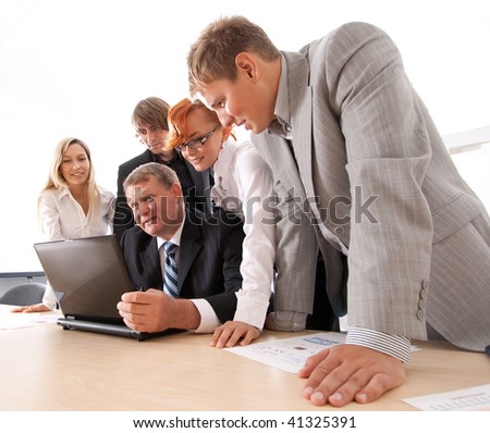 Wide angle shoot of business group of two young ladies, two young men and a mature boss at work isolated on white