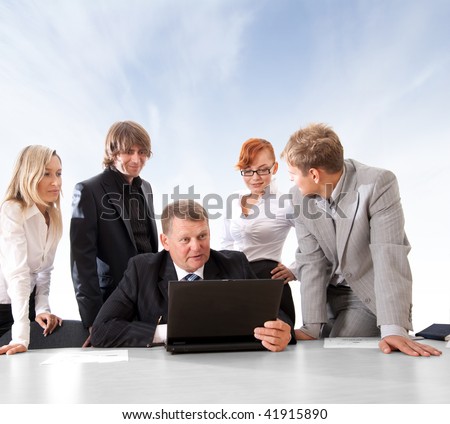 Business group of two young ladies, two young men and a mature boss at work over abstract sky background