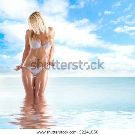 Sexy body of young attractive lady over natural background of sea and sky