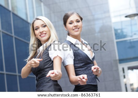 Two attractive business women over modern street background