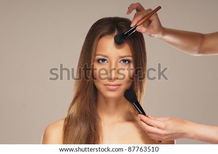 Studio photo of make-up process over grey background