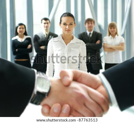 Group of business people over futuristic background with a blurry handshake in front