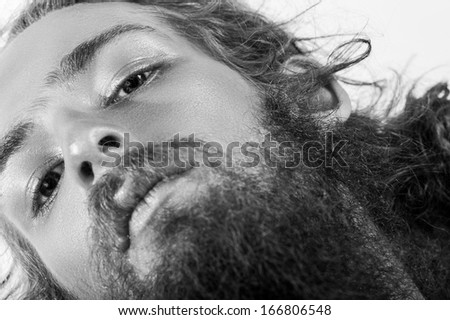 closeup wild hipster man face long beard and hair black and white