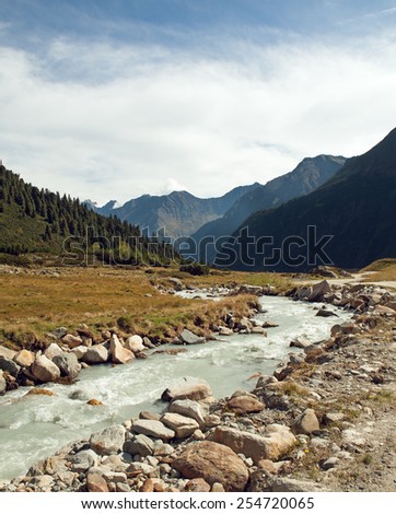 Beautiful summer Alpine mountain river view and sunshine in sky
