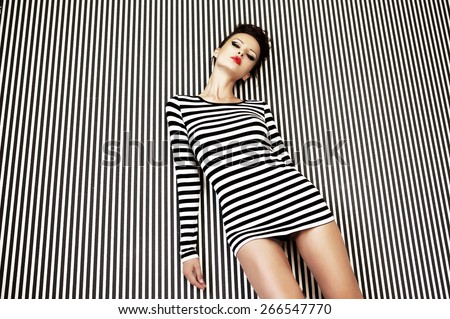 fashion woman in striped dress on striped background in studio