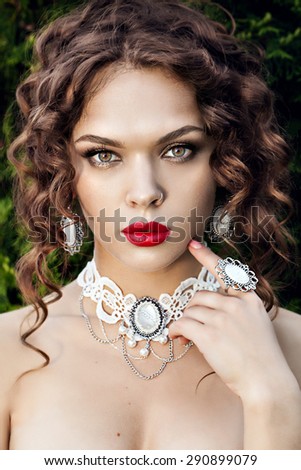 portrait of a beautiful brunette girl with luxury accessories. Beauty with jewelry.