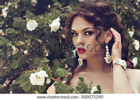 portrait of a beautiful brunette girl with luxury accessories. Beauty with jewelry.