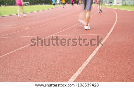 Running track with running legs in sport shorts and jogging shoes