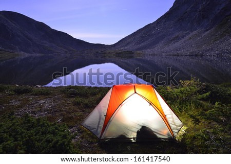 tent on camping ground near the lake at night during summer