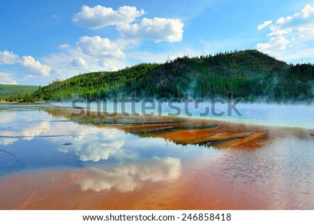 red steamy surface and reflection of the clouds in Midway Geyser Basin in Yellowstone National Park, Wyoming