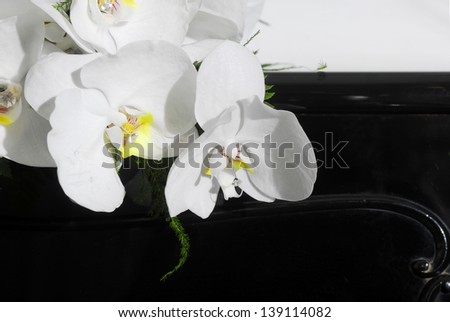 Elegant wedding bouquet made with white flowers on black piano