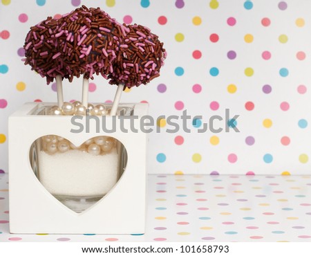 three cakepops in a little box with a heart on it background card