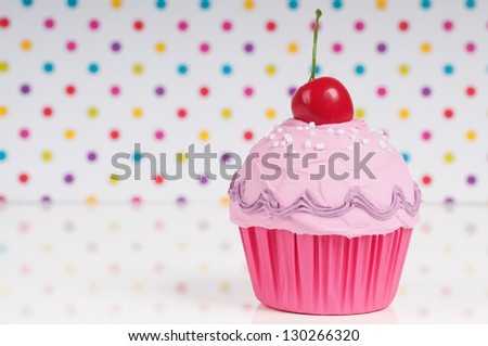 pink princess cupcake with cherry on top on a dotted background. birthday card design.