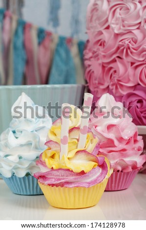 three cupcakes in blue pink and yellow