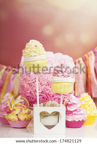 Pink and yellow cupcakes and cake party setting