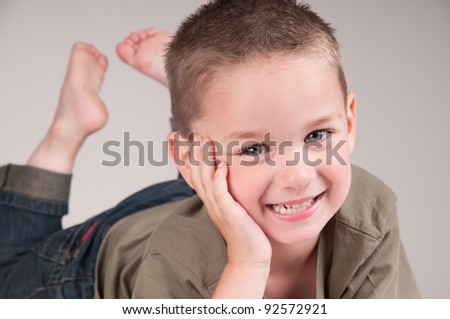 adorable little boy laying down with feet in the air