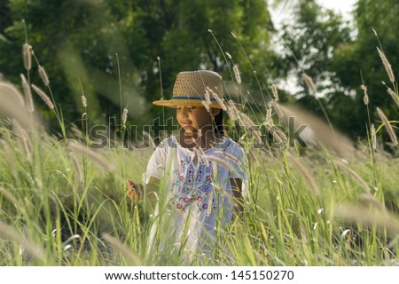 Beautiful girl with hat and white blouse walking and smiling through a pasture
