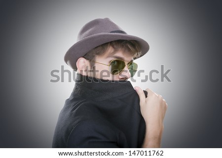 Young adult trying to hide her face with sunglasses and a jacket