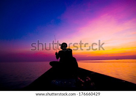 Lonely man fishing silhouettes on sunset sky beautiful lagoon