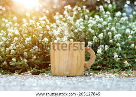 morning coffee with wood cup and white flower grass.
