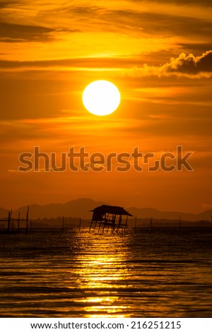 The old wooden pavilion, on the Black Lake. With sunset sky, thailand.
