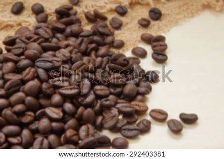Blur image of Coffee beans on the wood.