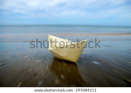 Motion into the sea of paper boats on beach.