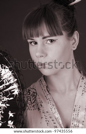 Beautiful young woman geisha in Asian costume with Asian fan black and white