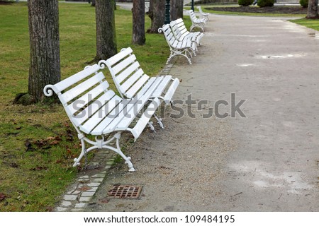 white benches in the Park along the path