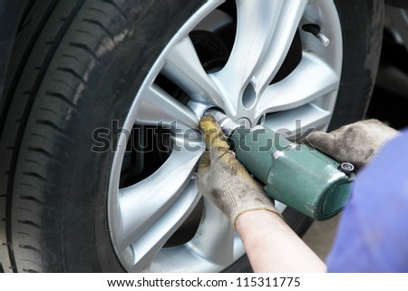 removing the tire of a car to replace the