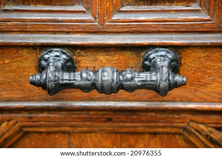 Old metal handle on the wooden door