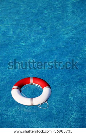Red life buoy floating in swimming pool