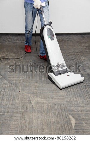 worker cleans the carpet, vacuum cleaner