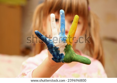 little girl with hands in paint