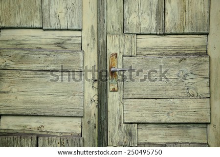 The pattern of old green door with metallic the handle of the door