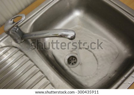 working water tap in a kitchen. Water flows into sink