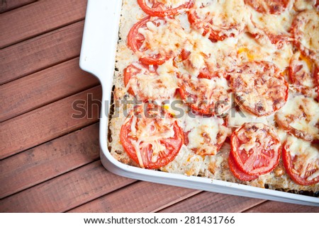 Delicious pie with tomato and grated cheese coating