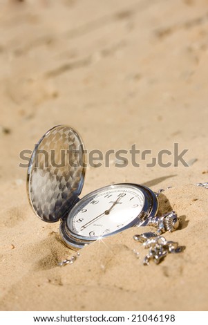 Old pocket watch in sand