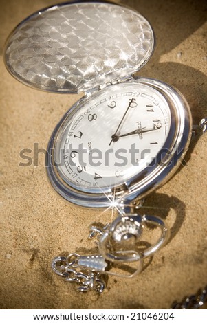 Old pocket watch in sand