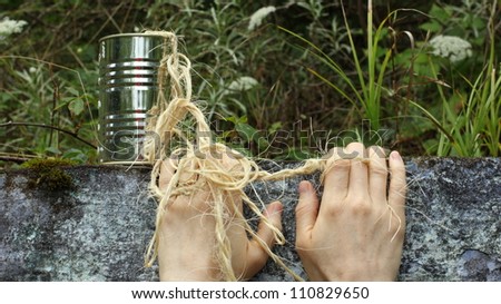 tin can, twine, and hands