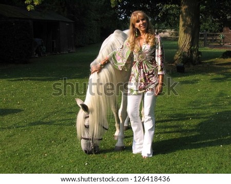 OXFORD - JULY 27: Julia Verdin wearing a top by Sky, Red Engine Jeans, and jewelry by Fileena with a horse on the set of the Feature Film \