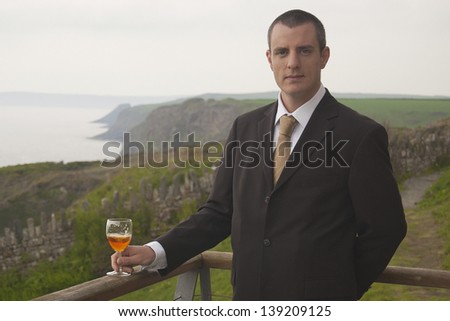 Man in Suit Drinking Wine