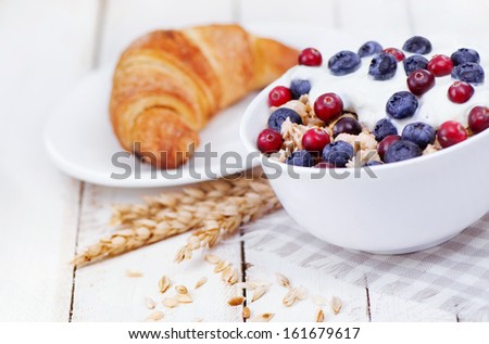 Muesli with yogurt  and berri,cowberry  bilberry with tasty croissant