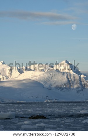 Antarctic mountains under the moonlight on a summer day.
