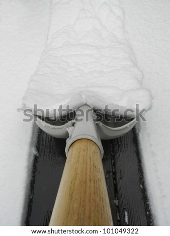 Shoveling snow off of a wooden deck Sierra Foothills Northern California.